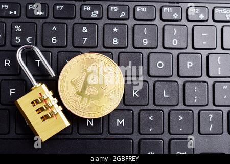 digital currency, bitcoin with lock on keyboard, cryptocurrency hacking concept. Stock Photo