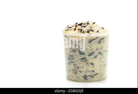 Three kinds of rice in a plastic rice measuring cup on white background, front view, close up image of mixed rice, white, brown, black. Stock Photo