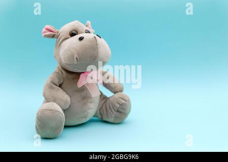 Stuffed animal hippo on blue background. Child soft toy, comforter for sleep.  Stock Photo