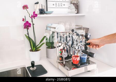 Coffee machine man barista making two espresso at home kitchen lifestyle. Morning breakfast Professional equipment at home or office Stock Photo