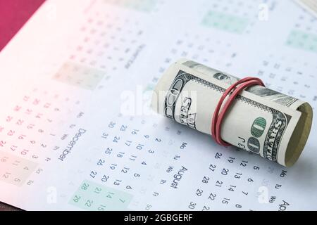 Office workplace desk with dollars and calendar. Counting money for salary. Investment savings. Finances, economy and home concept. Business budget of Stock Photo