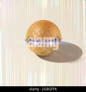 Stylish cover for a new music album. Golden ball with false eyelashes and highlights in the eyes. Abstract background aesthetics and minimalism. Stock Photo