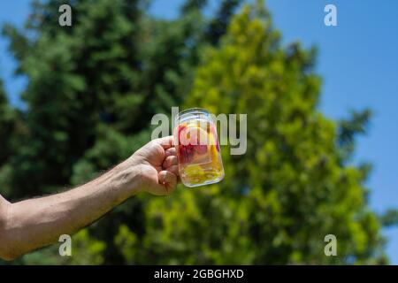 Detox drink made from fresh fruits and vegetables, with a backdrop of blue sky. Selective Focus Jar Glass Stock Photo