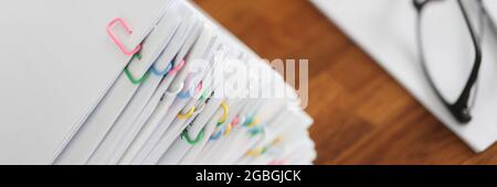 Lot of documents with colored paper clips lying on desktop closeup Stock Photo