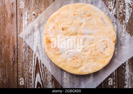 Flatbread, pita or pizza crust on wooden kitchen table Stock Photo