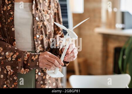Close-up of architect holding architectural model of windmill standing at office Stock Photo