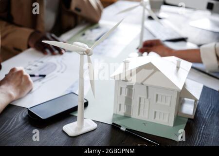 Close-up of model of new modern building on the table with architects working together at the table Stock Photo