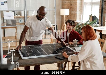 Group of engineers working at the table in team they developing new solar battery at office Stock Photo