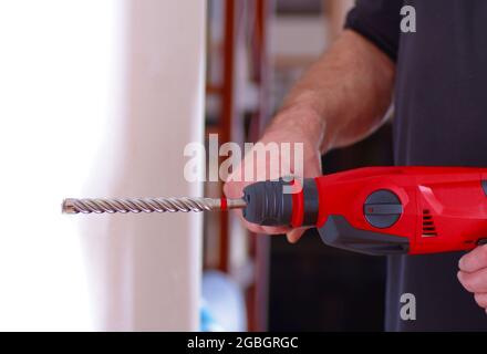 Man drilling a hole in the wall Stock Photo
