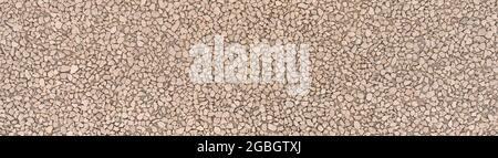 Rough exposed aggregate concrete with angular stones in panoramic close-up Stock Photo