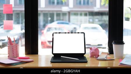 Computer tablet with blank white screen on wooden workspace. Online Education or Graphic Designer Concept Stock Photo