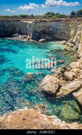 Torre Sant Andrea near Torre dell'Orso, Salento sea coast, Apulia, Italy. Beautiful rocky Seascape with cliffs in Puglia. Blue turquoise saturated clear water. Bright Summer day. No people. Stock Photo