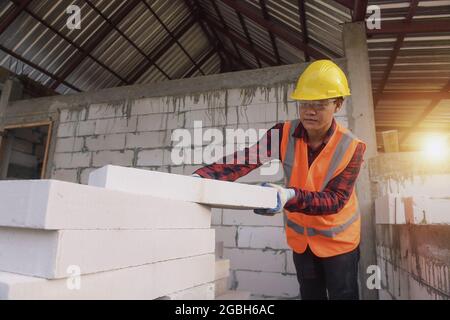 Construction worker picking up bricks Stock Photo
