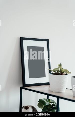 Blank wooden photo frame stands in the interior on a white background. Mockup poster frame. Stock Photo