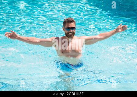 happy handsome man in glasses swimming in pool on summer, vacation Stock Photo