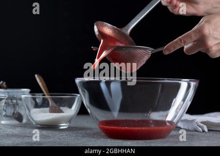 Jam Making - straining fruit through muslin bag to remove seeds ad skins  Stock Photo - Alamy