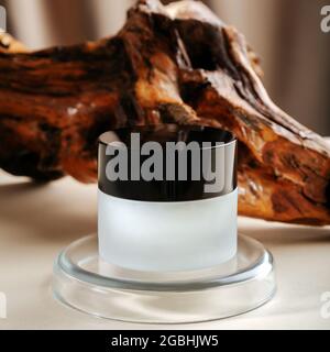 Skincare Cream in transparent round jar on color beige background on petri dish laboratory glassware podium pedestal platform. Skin care cosmetics Stock Photo