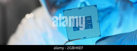 Scientist developer in protective suit holds microcircuit Stock Photo