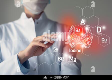 Essential nutrients for Thyroid Gland health including Iodine, Selenuim, Vitamin B6, Cuprum. Blurred portrait of doctor holding highlighted  red Thyro Stock Photo