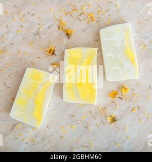 Many various white homemade bar soaps, spa bath products for skincare. Flat lay hygiene toiletries on marble table. Square closeup. Natural olive soap Stock Photo