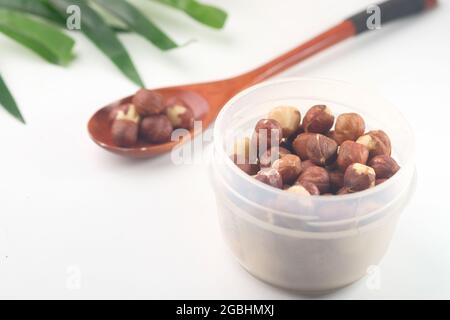 hazelnuts in a container on white background, Stock Photo