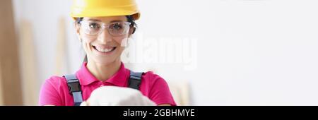 Portrait of smiling woman builder in yellow hard hat Stock Photo