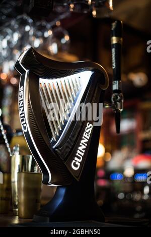 Bucharest, Romania - August 5, 2021: Illustrative editorial image of a Guinness beer tap in a pub in Bucharest.