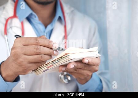 doctor hand writing prescription on desk, close up. Stock Photo