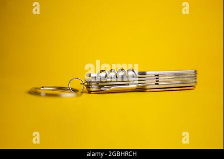 multifunctional metal knife on a yellow background. Stock Photo