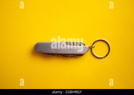multifunctional metal knife on a yellow background. Stock Photo