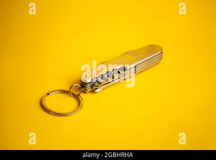 multifunctional metal knife on a yellow background. Stock Photo