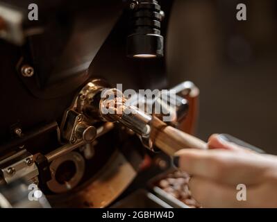 Male worker using professional coffee roasting machine Stock Photo
