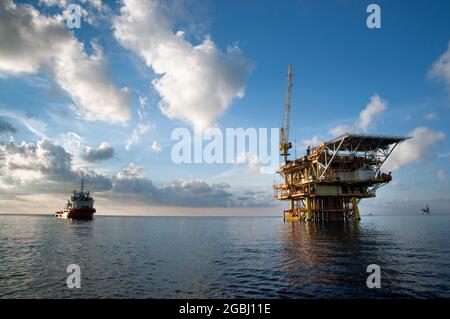 offshore platform drilling at sea during morning with offshore supply vessel