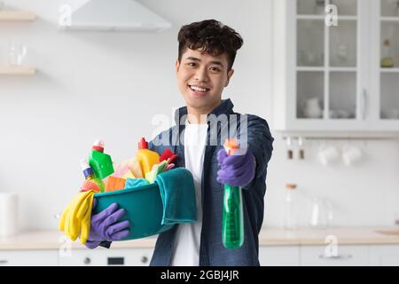 Handsome asian guy showing his cleaning tools Stock Photo