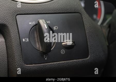 Close-up of the car's headlight control switch. A detail of the car's interior. Stock Photo