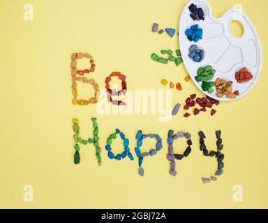 wish to be happy is written from multicolored chocolates in form of sea pebbles on yellow background. Birthday card. palette for watercolors. concept Stock Photo