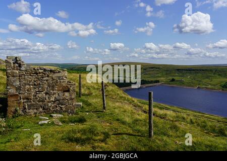 Remains of a small derelict building with Scar House Reservoir in the background, Nidderdale, North Yorkshire, England, UK. Stock Photo