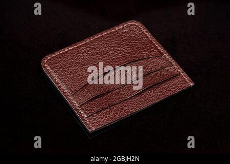 Leather brown business card holder on a black background. Stock Photo
