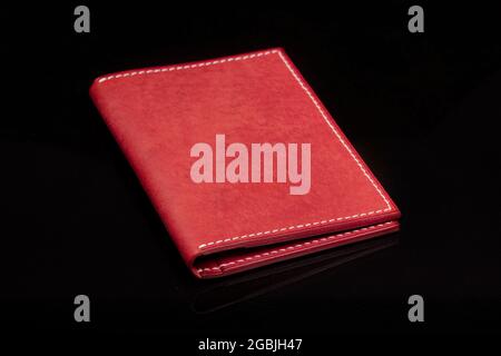 Leather wallet in red on a black background. Stock Photo