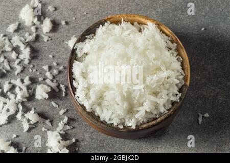 Raw Organic Shredded Coconut Flakes in a Bowl Stock Photo