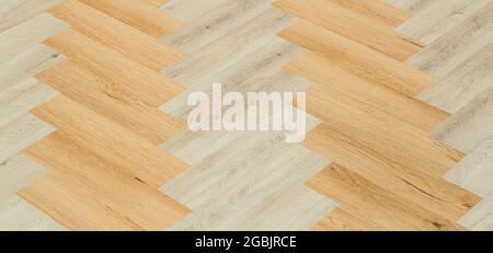 Laminate and parquet with herringbone background. Wooden floor with a chevron pattern in the living room of the designer interior. High quality photo Stock Photo