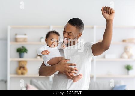 Hapiness Of Fatherhood. Joyful Black Dad Enjoying Spending Time With Infant Child Stock Photo