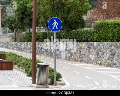 sign of a pedestrian street next to a bike path on the waterfront of a seaside town Stock Photo