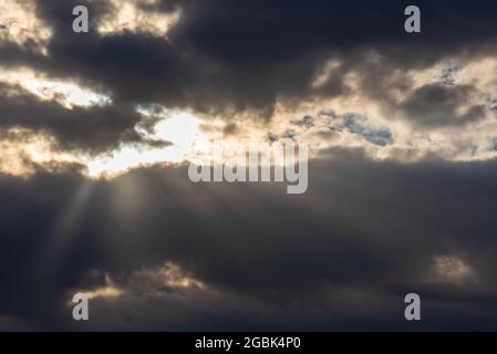 Rays of light shining throug dark clouds.Beautiful dramatic sky with sun rays.dramatic sky sun rays. Stock Photo