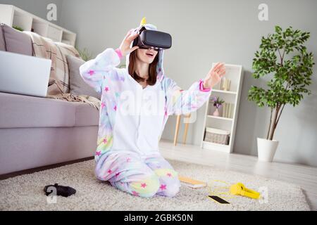 Photo of crazy interested curious lady have virtual reality first time experience wear vr goggles kigurumi indoors