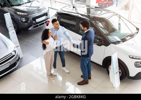 Young middle-eastern couple visiting automobile showroom or exhibition Stock Photo