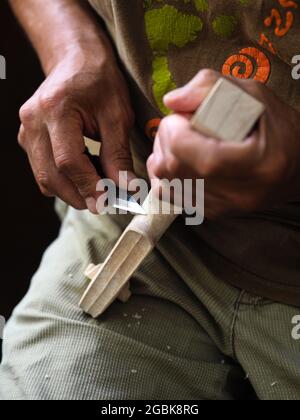 Luthier working on violin head and curl Stock Photo