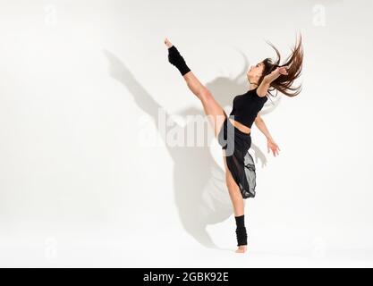 Young woman doing dynamic leg stretch exercise in special machine under ...