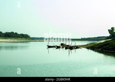 Fishing boats are tied to the river bank and when the river water has almost dried up and it is due to global warming and it is slowly endangering the Stock Photo