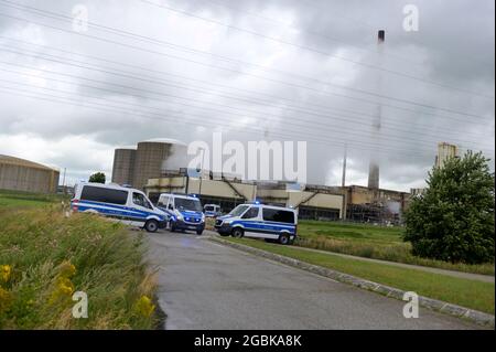 31 July 2021, Schleswig-Holstein, Brunsbüttel: Police vehicles block the access road to a chemical company. During a demonstration against a planned terminal for liquefied natural gas (LNG), activists of the alliance 'Ende Gelände' occupied several tracks in an industrial area. Photo: Jonas Walzberg/dpa Stock Photo